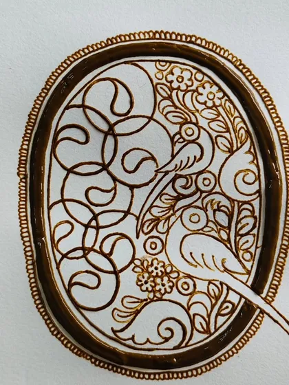 The initial outline of the parrot cutwork design, showing the clean lines and composition before the filling process begins.