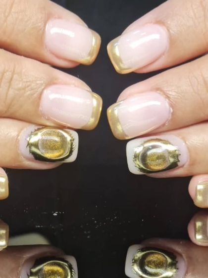 A close-up of the 3D gold accent on the modern gold-tipped French manicure.