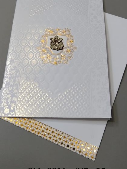 This elegant white invitation features a beautiful Ganesha emblem made of gold foil. The textured paper and gold border give it a luxurious feel at an affordable price.