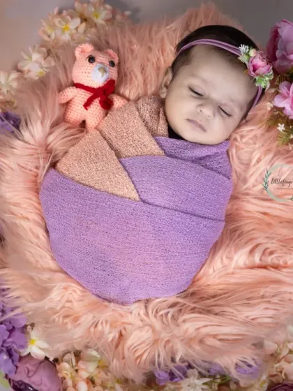 Wrapped in shades of lavender and peach, this little one is sleeping so soundly. I use a variety of soft wraps and props like this little teddy bear to add a touch of sweetness to each newborn portrait.