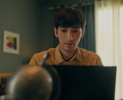 A different scene from a SanDisk ad, showing a character in a home office setting. The styling is simple and relatable, with a casual button-down shirt for a work-from-home look.