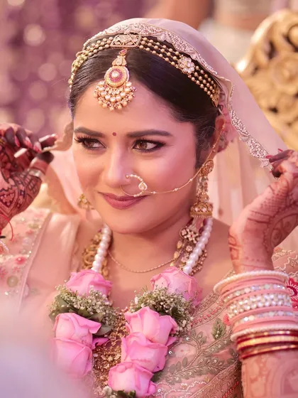 A close-up of the bride during a ritual. Her makeup is subtle and elegant, allowing her natural beauty to shine.