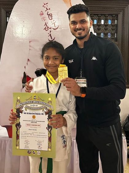 Posing with a national gold medalist. Her success inspires all the other students at the academy.