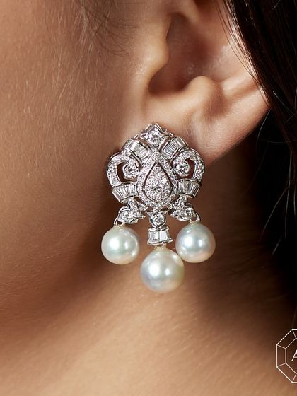 Fear of blending in? These diamond and pearl earrings are designed to make you stand out effortlessly. The intricate design features pear-cut diamonds and dangling South Sea pearls, offering a look of pure sophistication.