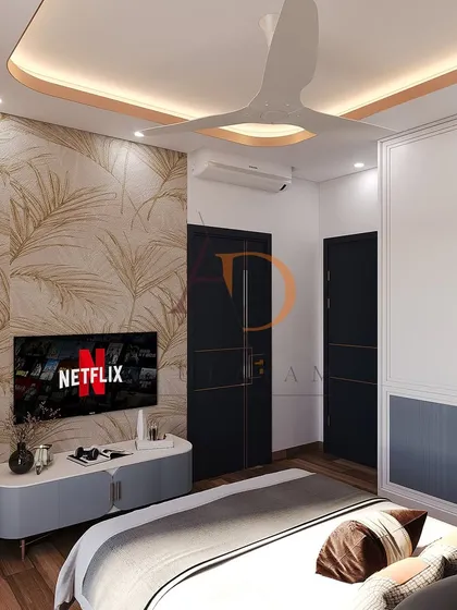 A wider view of the bedroom, showing the TV wall, dual-tone wardrobes, and the warm cove lighting in the ceiling that adds a cozy ambiance.