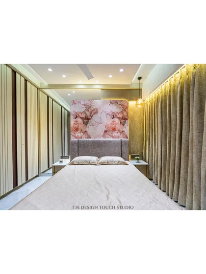 A full view of the bedroom, showing the interplay between the floral headboard, the neutral-toned wardrobes, and the warm, ambient lighting. The space feels both luxurious and inviting.