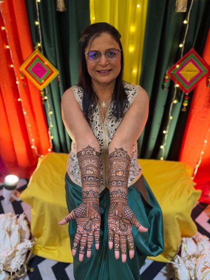 A closer look at the intricate henna design for the groom's mother, featuring classic patterns that extend up the arm.