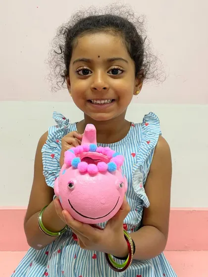 This adorable little artist is so happy with the pink whale planter she painted and decorated all by herself.