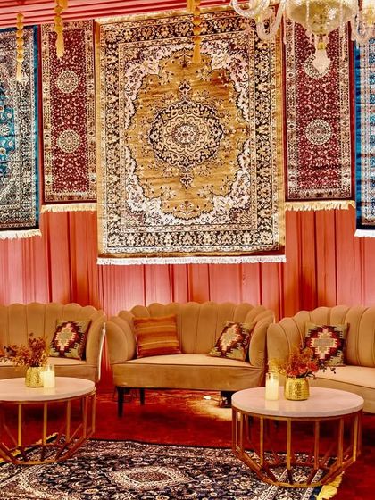 A cozy lounge nook with scalloped velvet sofas set against a backdrop of beautiful Persian rugs, creating a perfect conversation pit.