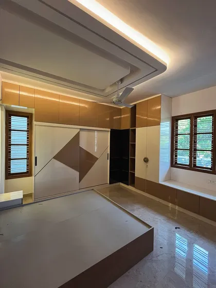 This bedroom showcases a sliding wardrobe with a geometric dual-tone pattern. The design also includes a bay window seating area, making the most of the available space and natural light.