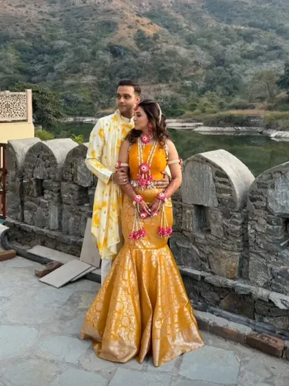 For this beautiful couple's Haldi ceremony, I designed a coordinated set that felt festive and personal. The groom wears a custom-printed yellow kurta, perfectly complementing the bride's bespoke mermaid skirt. My goal is to create looks where couples coordinate without being overly matched.