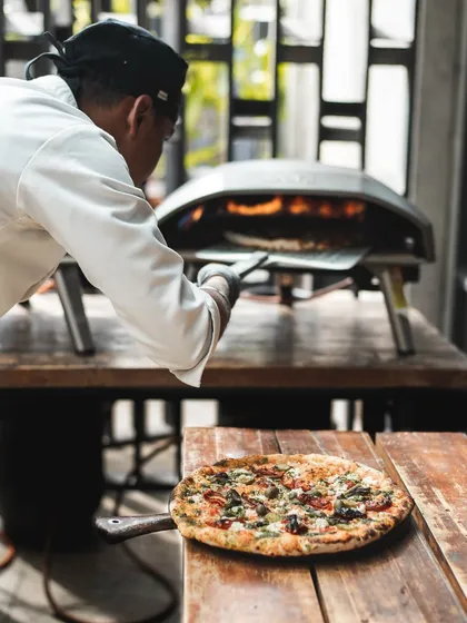 No space is too small for a pizza party. For more intimate gatherings, we bring our portable Ooni ovens that deliver the same wood-fired flavor in a compact setup.