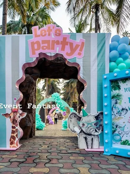 The entrance to a "Young, Wild, and Three" party. This fun and inviting setup features a blue-lit welcome sign, cute animal cutouts like a zebra and a tiger, and a striped archway that beckons guests into the celebration.