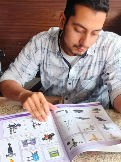 A young agricultural entrepreneur goes through our catalog, which showcases the wide variety of irrigation accessories we provide. We aim to be a one-stop solution for all smart irrigation needs.