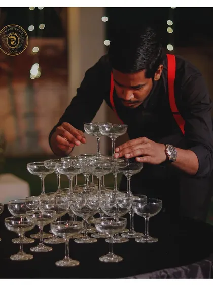 Precision and focus are key. Here, our bartender meticulously builds a champagne tower, ensuring it's perfect for the toast.