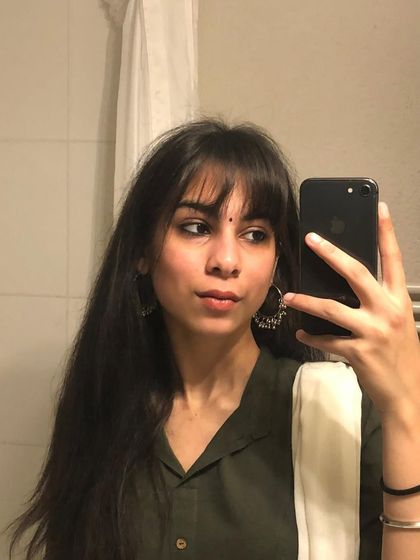 A perfect mirror selfie showing how versatile front bangs can be. They work just as well for a traditional look as they do for a modern one, adding a touch of sophistication.