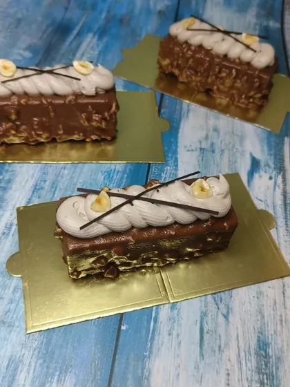 A close-up of the hazelnut mousse pastries, showing the crunchy nut coating and smooth cream topping.