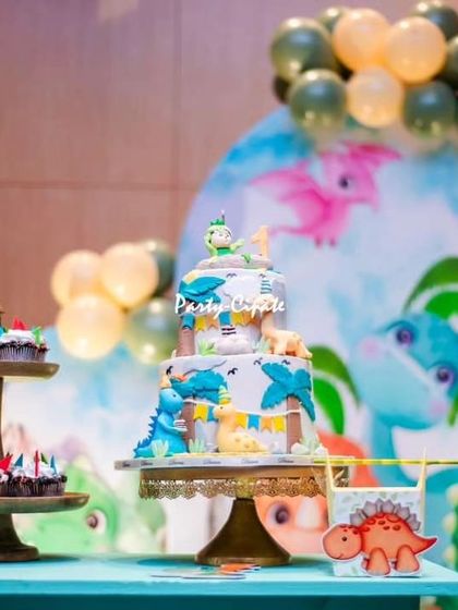 The tiered birthday cake was decorated with cute dinosaurs and tropical leaves, perfectly matching the party's theme.