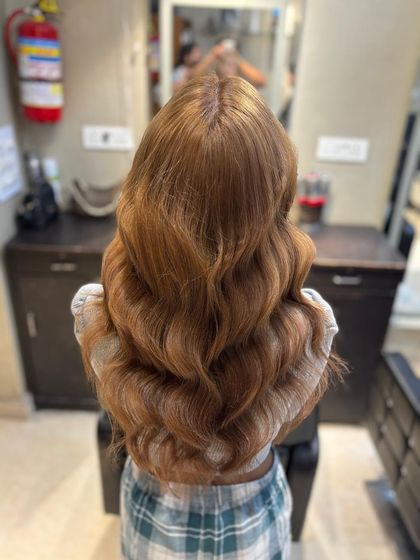 The stunning allure of ash blonde. This cool-toned shade, styled in beautiful waves, is perfect for elevating your hair game.