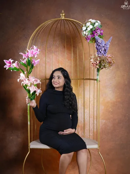 Another lovely solo portrait from the same setup. The mother-to-be holds a bouquet of lilies, adding a fresh and beautiful element to her maternity photo.