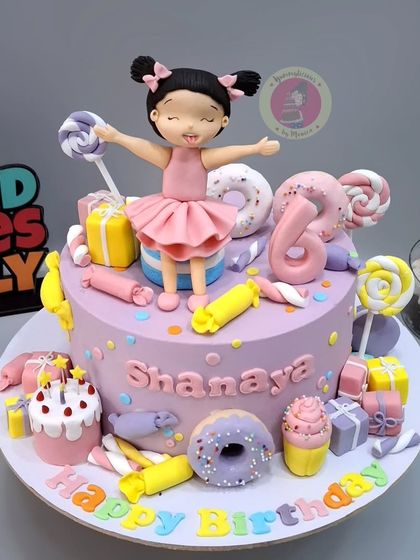 A vibrant Candyland cake for Shanaya's 6th birthday, topped with a happy girl figurine and decorated with all sorts of fondant sweets.