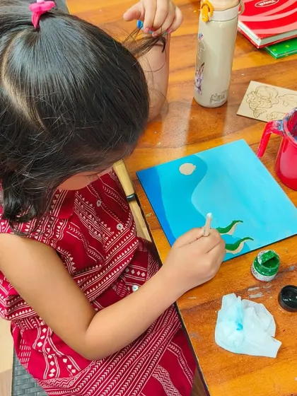 A student carefully painting her project during our summer camp. We provide a supportive space for kids to focus and bring their creative ideas to life.
