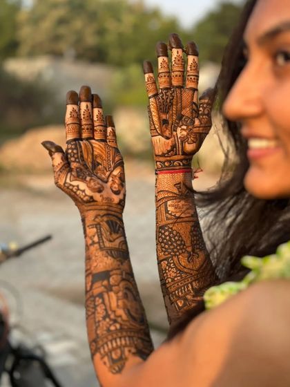 A candid shot of a bride showing off her detailed story-telling mehendi.