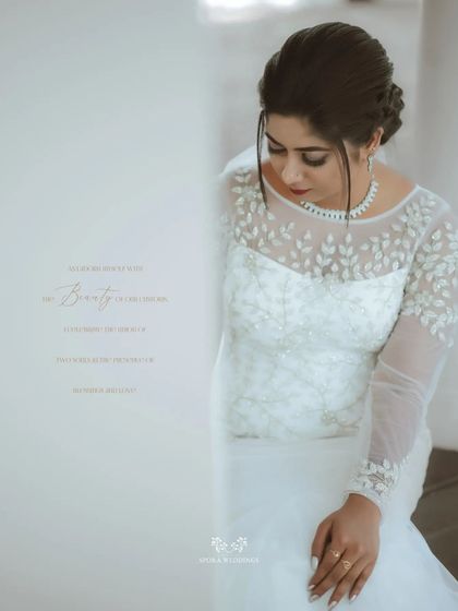 A serene portrait of the bride, her elegant gown with leaf-patterned embroidery beautifully captured in a quiet moment.