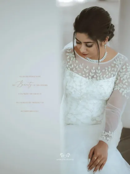 A serene portrait of the bride, her elegant gown with leaf-patterned embroidery beautifully captured in a quiet moment.