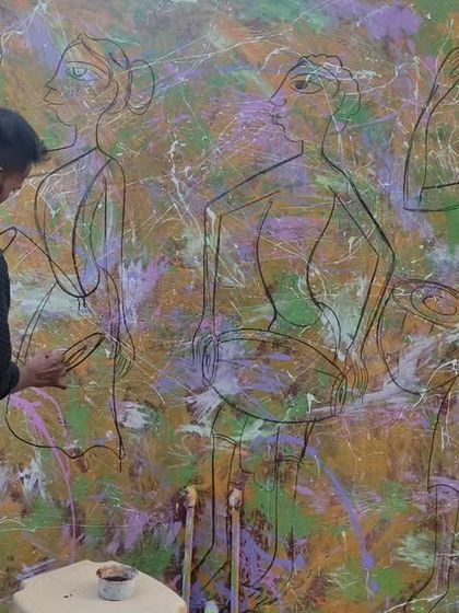 An artist at work on a large-scale abstract wall mural, starting with the initial line drawing over a textured background.