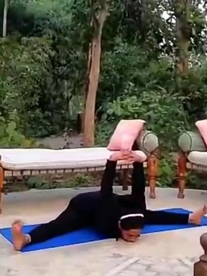 A photo of me in Samakonasana, the side splits pose, in a garden. This image represents the idea that a woman can bend without breaking, celebrating the strength, power, and flexibility that yoga cultivates.