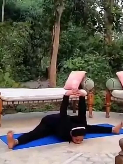 A photo of me in Samakonasana, the side splits pose, in a garden. This image represents the idea that a woman can bend without breaking, celebrating the strength, power, and flexibility that yoga cultivates.