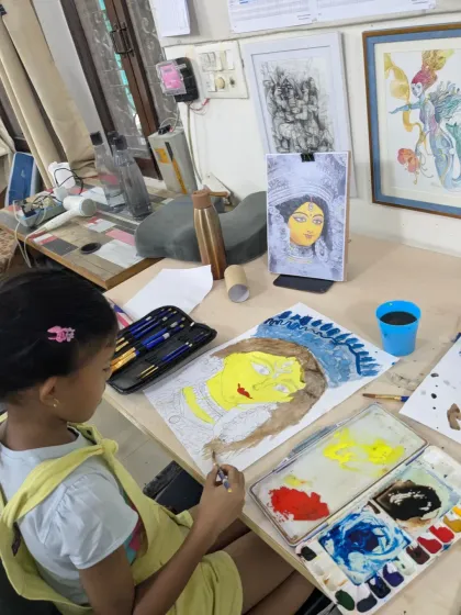 Adding layers of color. Naomika is focused on painting her Durga artwork, learning how to apply watercolor washes and build up tones.
