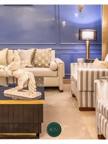 A detailed shot of a living room we designed, focusing on the striped accent chairs and the contemporary dark coffee table with a horse sculpture. The layering of textures and decorative items creates a rich, personalized space.