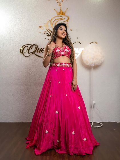 A client posing confidently in the bright pink lehenga.