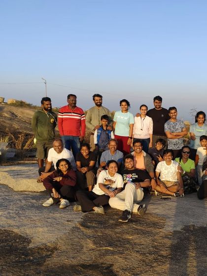 A large and happy group, including children, posing for a photo after the sunrise trek.