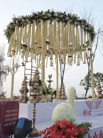 It's the details that bring a mandap to life. This setup features a beautiful swan crafted entirely from white flowers and traditional brass lamps, adding a touch of classic elegance to the sacred space.