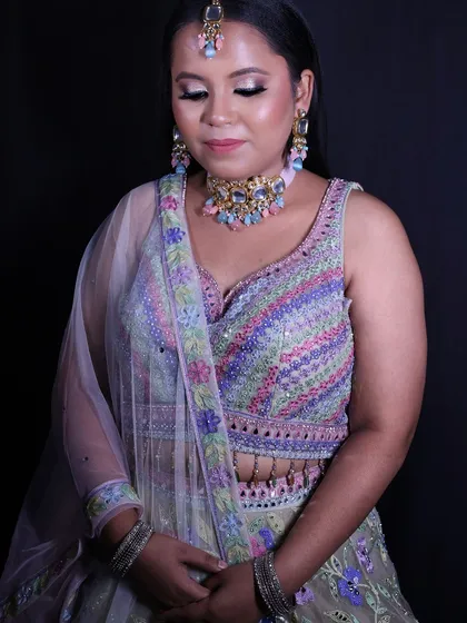 A beautiful shot of the client in her pastel engagement lehenga, highlighting the delicate jewellery and soft makeup that completes her look.