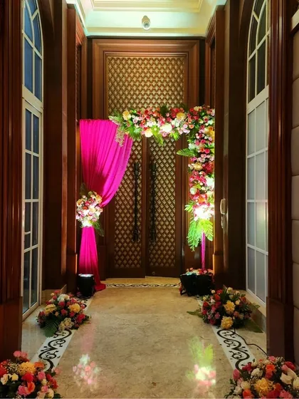 The floral and drape entrance, viewed from the hallway, creates a beautiful frame and builds anticipation for the celebration inside.