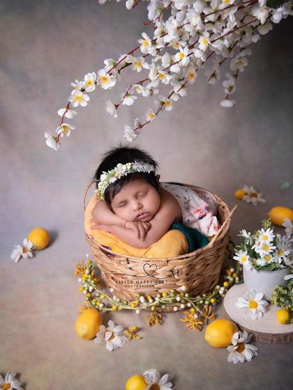 Delicate as a blossom. This baby girl, sleeping in a basket under a branch of white flowers, looks like a painting. The lemons add a fresh, unexpected pop of color.