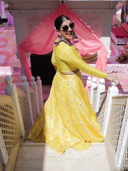 A playful shot of me on the stairs in my yellow Haldi outfit. It's important to have fun with it and embrace the festive spirit.