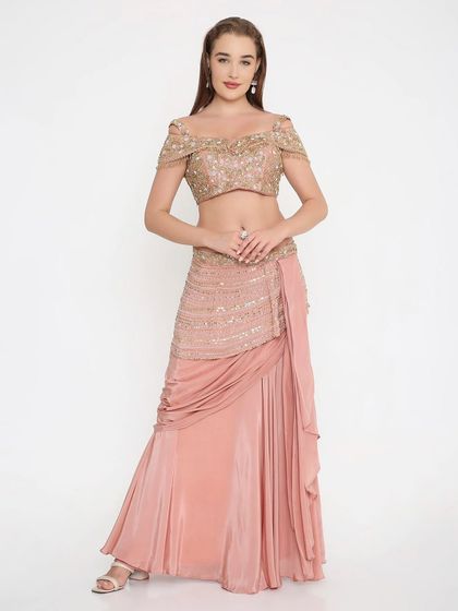 A full look at our custom-made soft peach draped outfit. The off-shoulder embroidered blouse and elegantly draped skirt create a silhouette that is both modern and graceful.