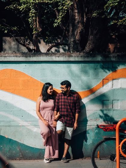 A couple holds hands in front of a colorful mural, blending their story with the art of the street. Urban environments provide endless opportunities for creative and vibrant couple portraits.