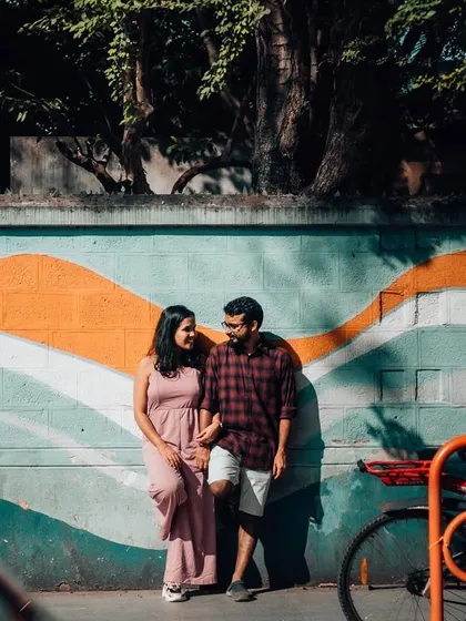 A couple holds hands in front of a colorful mural, blending their story with the art of the street. Urban environments provide endless opportunities for creative and vibrant couple portraits.
