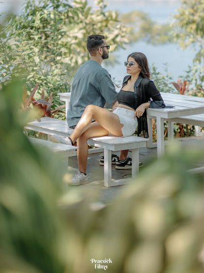 A cool, candid moment during a pre-wedding shoot. The couple relaxes on a bench, their modern style and easy confidence making for a effortlessly chic portrait.