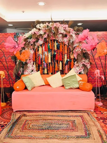 The full view of the Mehendi stage, complete with decorated umbrellas and plush seating, creating a comfortable and stylish space for the bride.