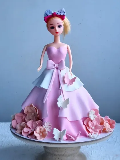 A classic Barbie doll cake, where the doll's skirt is made entirely of cake and covered in fondant. I teach how to structure the cake, create the layered dress effect, and add delicate fondant flowers and butterflies.
