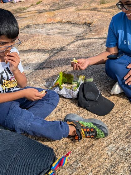 A picnic with a view is the best reward after a good trek. Here, a mother and son share a snack and a quiet moment, soaking in the beauty of the outdoors.