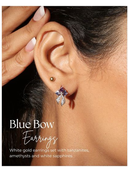 The Blue Bow earrings worn by a model. They are not your average bow, glowing with tanzanite blues, amethyst purples, and the shimmer of white sapphires.