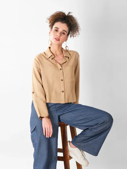 A full-length shot of the same outfit, showing how the shirt is styled with wide-leg denim pants.